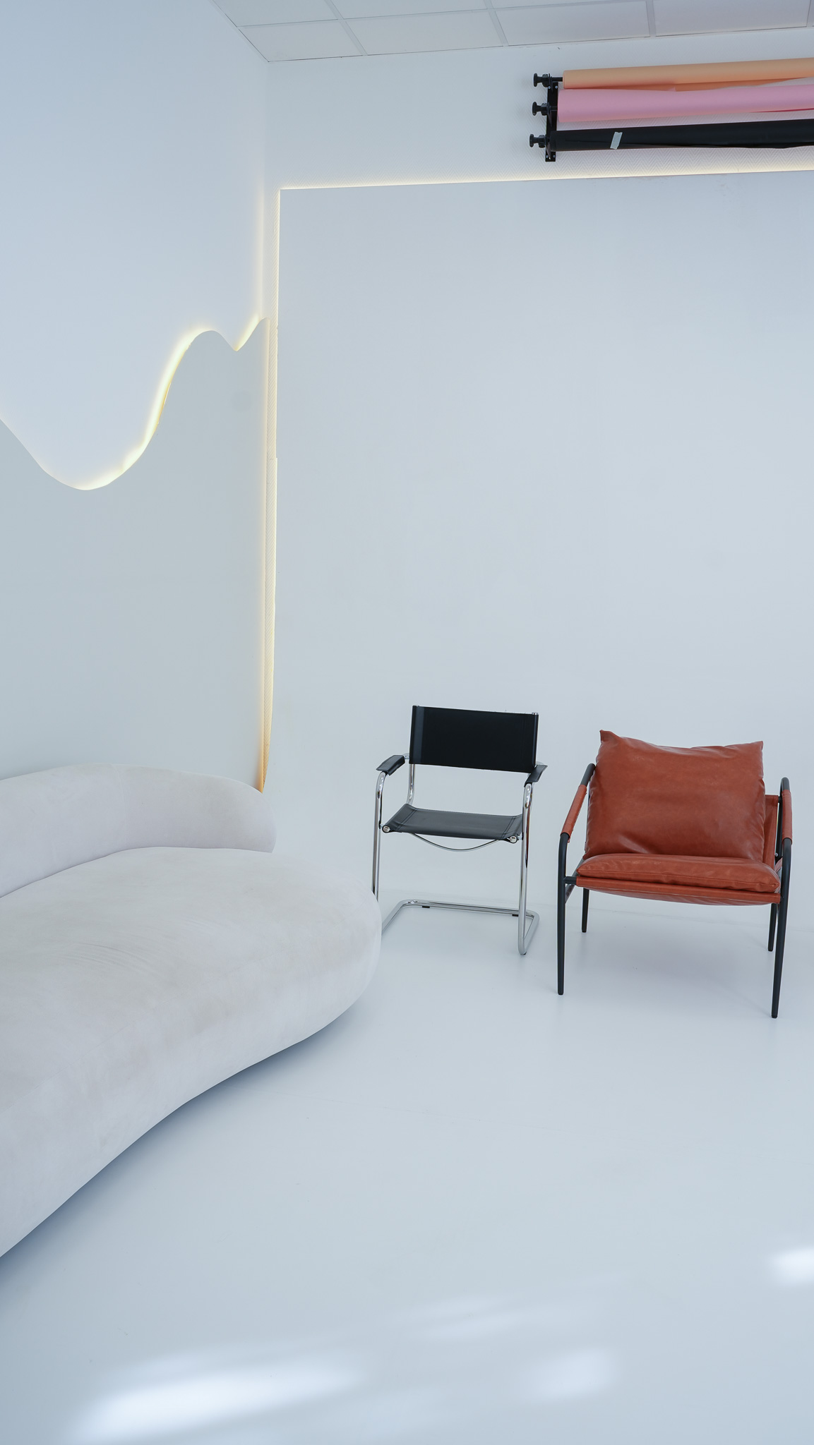 Studioraum mit Sofa-Insel, Freischwinger und cognacfarbenem Ledersessel