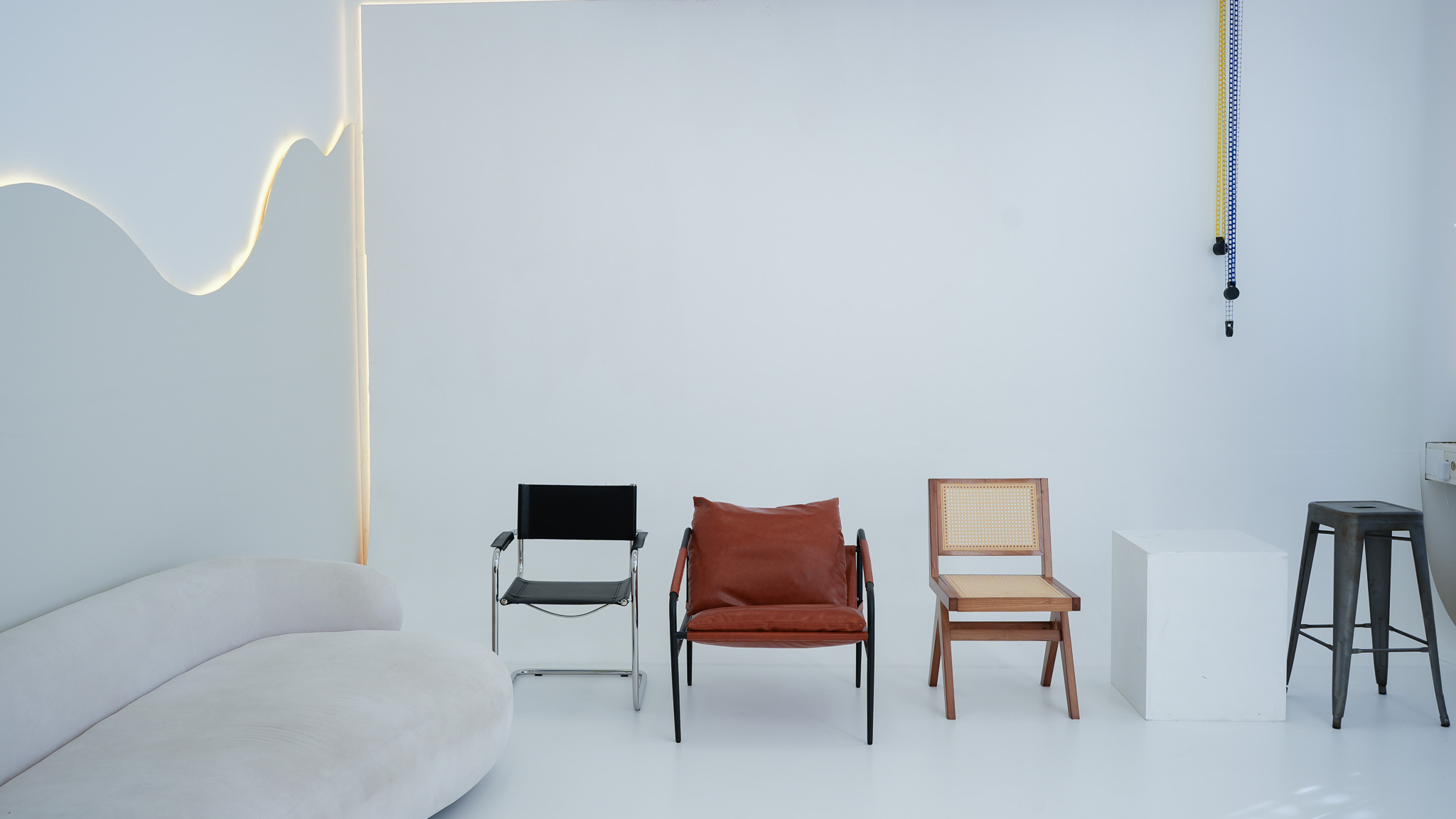 Fotostudio MR Studio Leipzig: weiße Sofa-Insel mit schwarzem Sessel, Ledersessel und Rattanstuhl